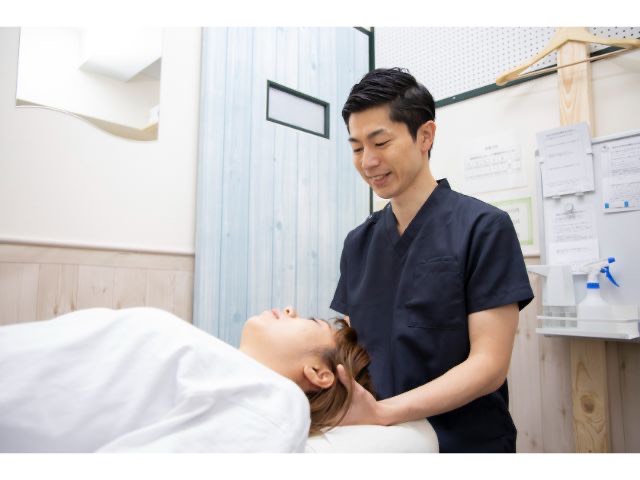 睡眠の質向上を目的に、頭蓋骨にやさしく触れて自律神経を整える整体施術の様子