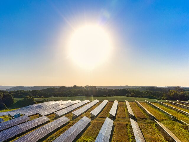 太陽が太陽光発電システムを照らしている写真