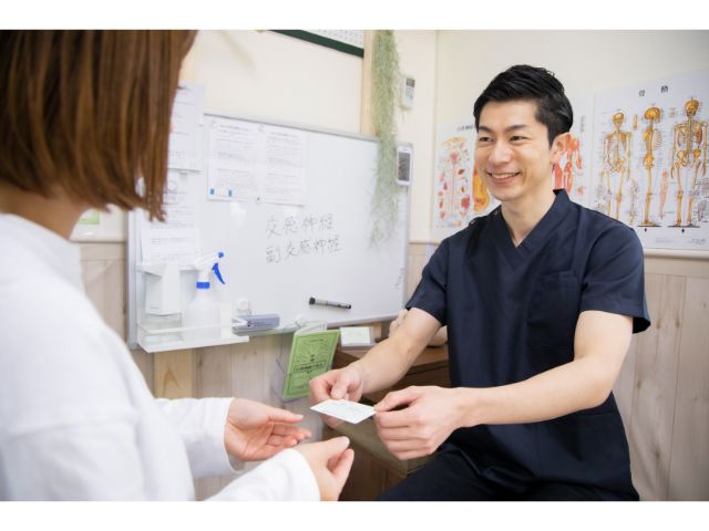 整体施術後に受付で案内をしている様子